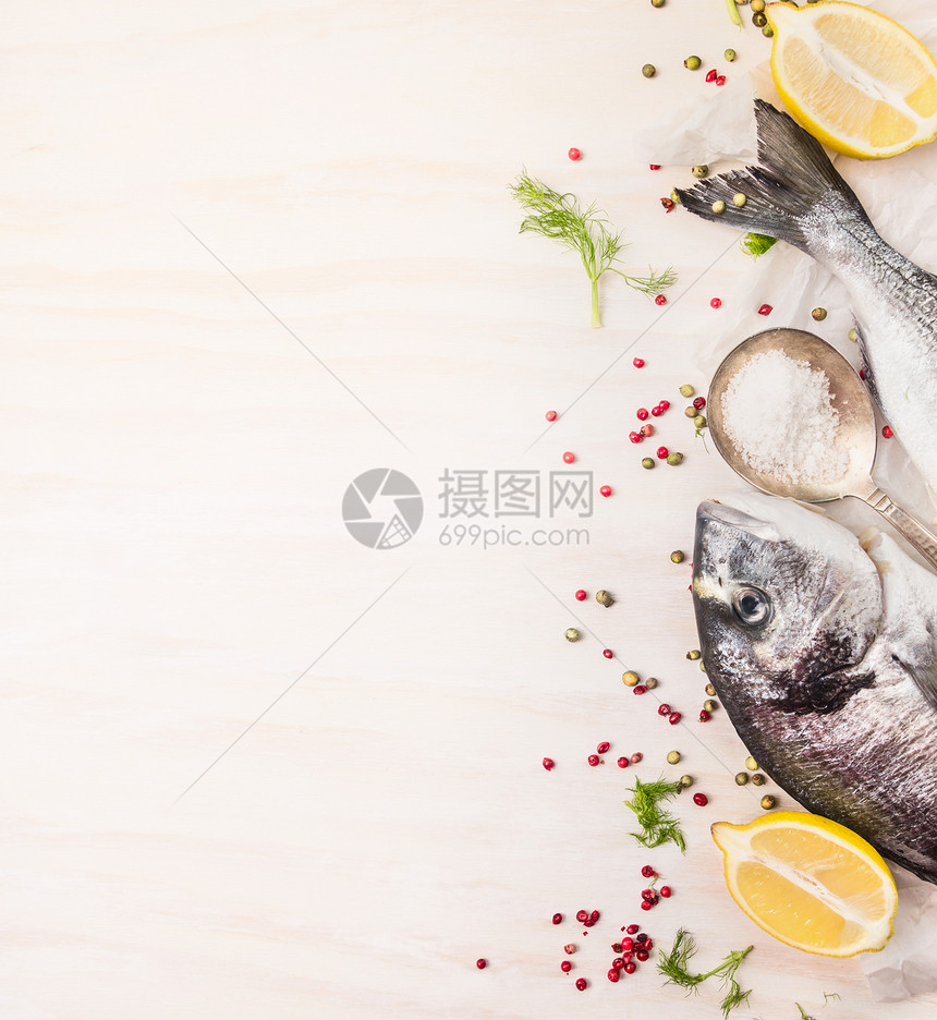 生多拉多鱼与多色胡椒,柠檬勺盐白色的木制背景,顶部视图,地方为文本图片