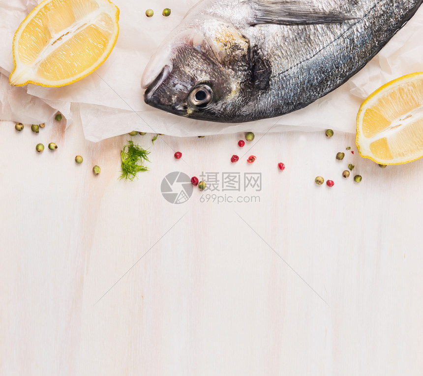 原始多拉多鱼与柠檬香料白纸上,木制背景,顶部视图,文字的地方图片
