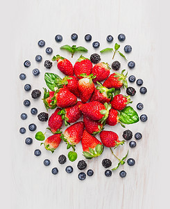 夏季浆果黑莓,蓝莓,草莓,白色木制背景上构图,顶部景色图片