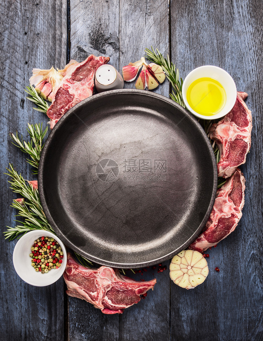 空盘与生羊肉腰部排骨肉,油,草药香料蓝色木制背景,顶部视图图片