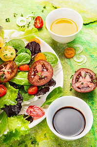 西红柿沙拉,橄榄油香醋绿色背景,顶部视图,背景图片