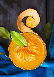 橘汁饮料橘汁与绿叶璃蓝色木制背景,顶部视图,背景