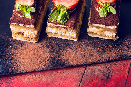 巧克力三层蛋糕提拉米苏蛋糕黑色石板红色木制背景上背景