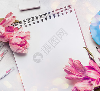 妇女春季工作与淡粉色郁金香,笔记本素描本彩色画笔标记,顶部视图图片