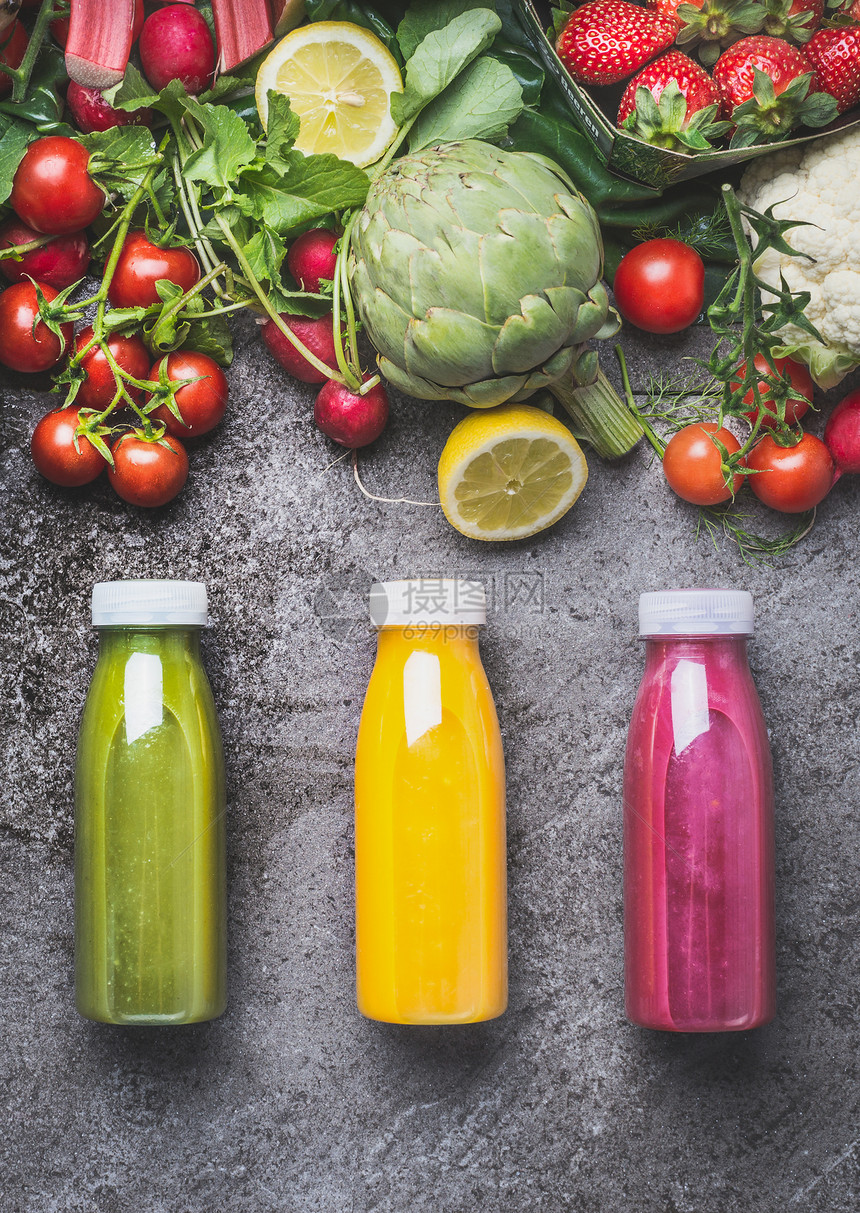 各种五颜六色的冰沙果汁饮料饮料瓶与新鲜成分水果,浆果蔬菜灰色混凝土背景,顶部视图健康食品的图片