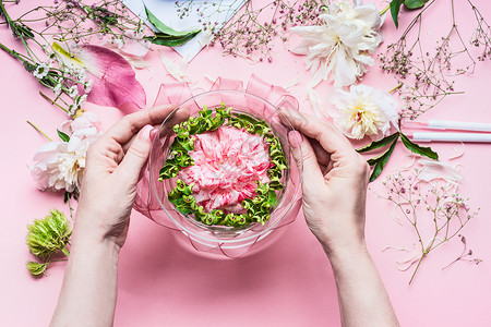 粉红色花店工作区百合花其他花,璃花瓶水女手节日鲜花安排,顶部视图图片