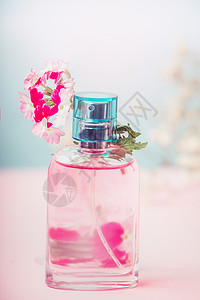 粉红色瓶花香水与花,天然化妆品美容粉彩背景,正视图图片