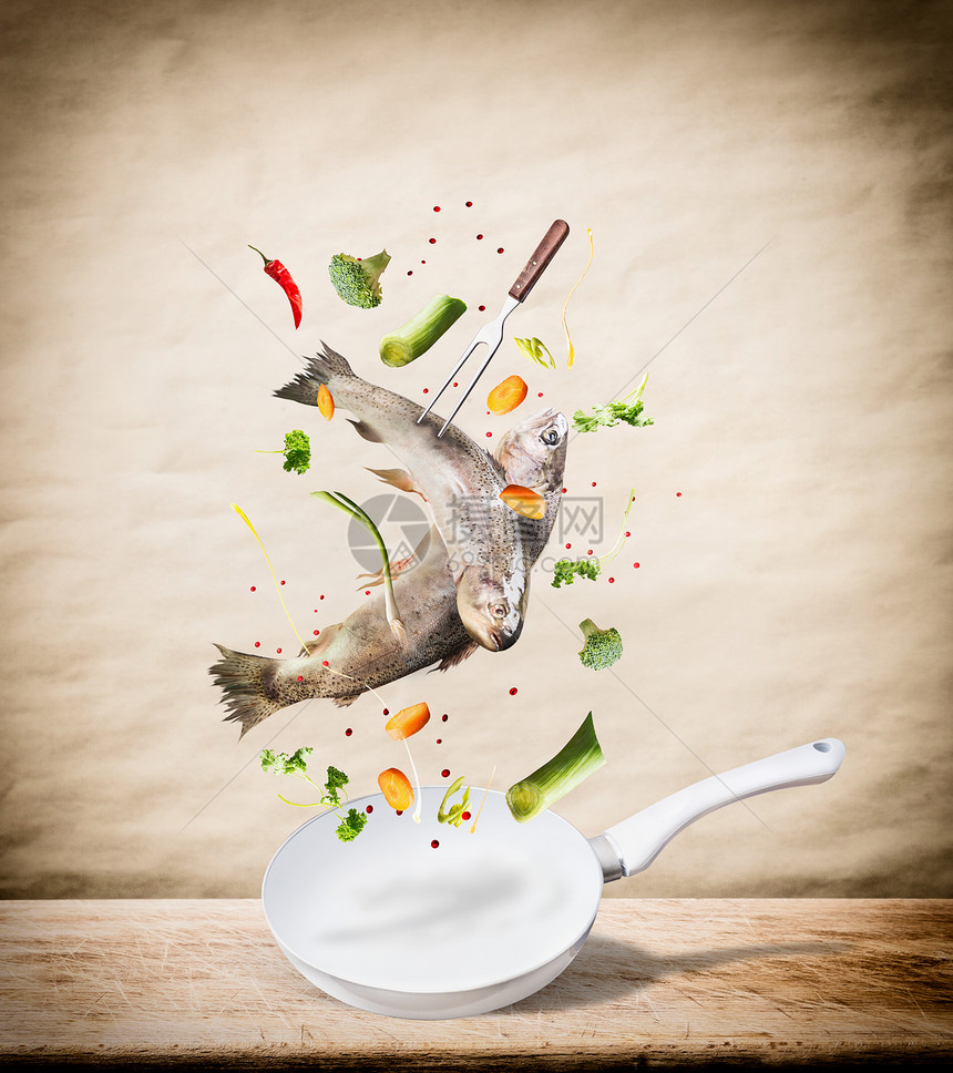 飞生全鳟鱼与蔬菜,油香料成分以上的煎锅,以美味的烹饪桌子厨房桌子米色背景健康食品饮食饮食图片