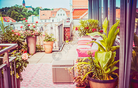 漂亮的夏季露台阳台的阁楼与花卉露台盆,户外家具良好的城市景观图片