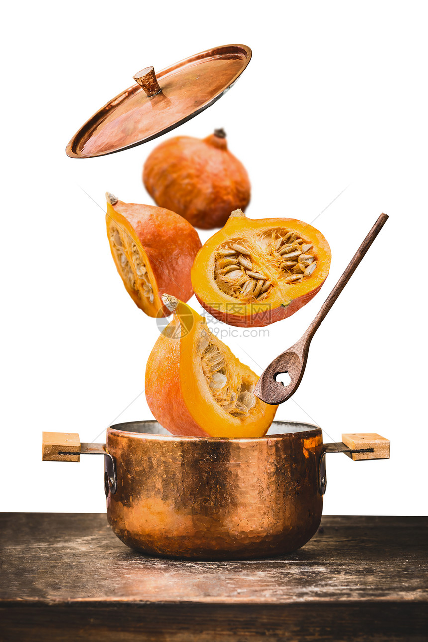 铜锅与飞南瓜与刀,打开盖子木勺桌子上,隔离白色背景,正视图秋季季节食谱饮食图片