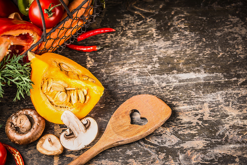 秋季素食烹饪与南瓜,蘑菇蔬菜乡村木制背景与烹饪勺子,顶部视图健康食品饮食观念图片