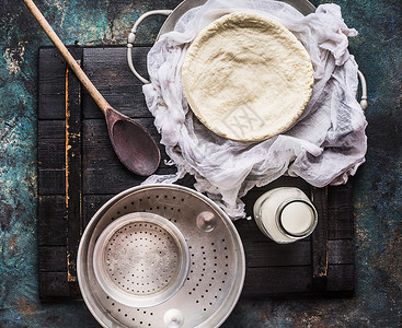 自制奶酪制作与乳酪布,瓶牛奶木勺乡村背景,顶部视图图片