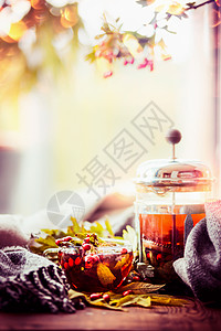 健康愈合秋茶与秋天浆果草药窗台上与叶子围巾自然背景,视图图片
