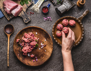 动词肉丸的制作女手把肉球放煎锅里厨房桌子上准备肉,强制肉,绞肉机勺子,顶部视图烹饪,食谱饮食背景