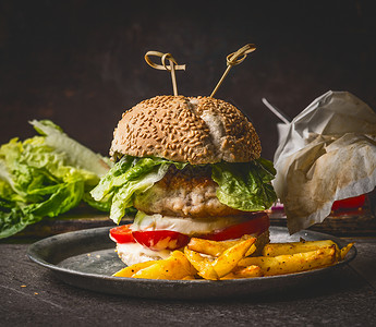 自制汉堡黑暗的乡村木制背景与炸薯条,正视图,快餐零食图片