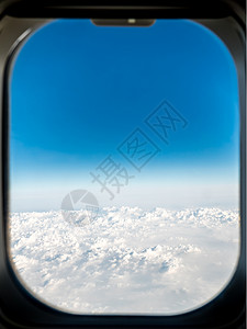 云层上方的飞机窗口视图图片