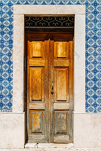 葡萄牙里斯本蓝色大理石瓷砖墙的老式木门图片