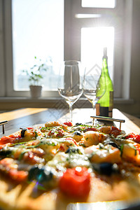 家里空酒杯绿色酒瓶新鲜烘焙披萨的图片图片