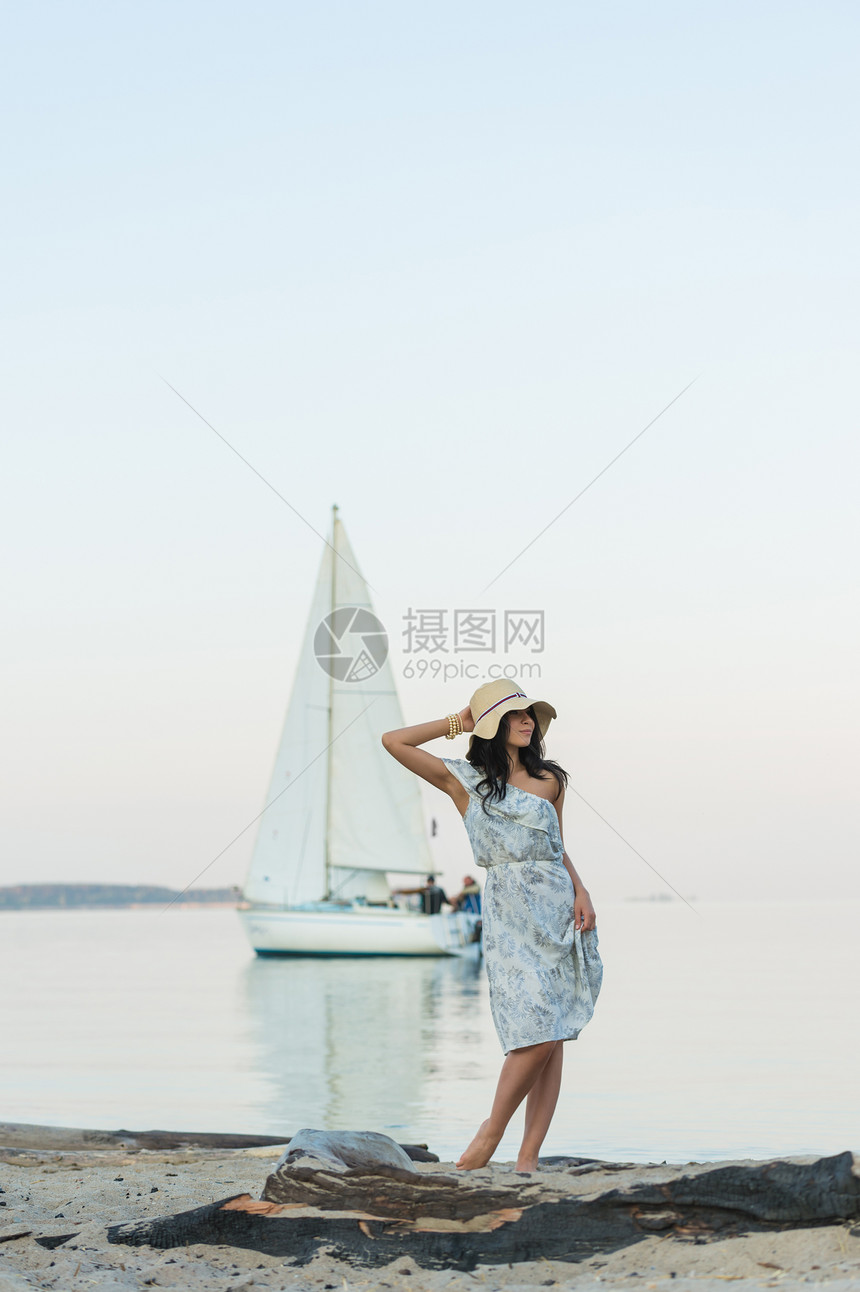 轻的女人热带海滩享受早晨,背景上游艇图片