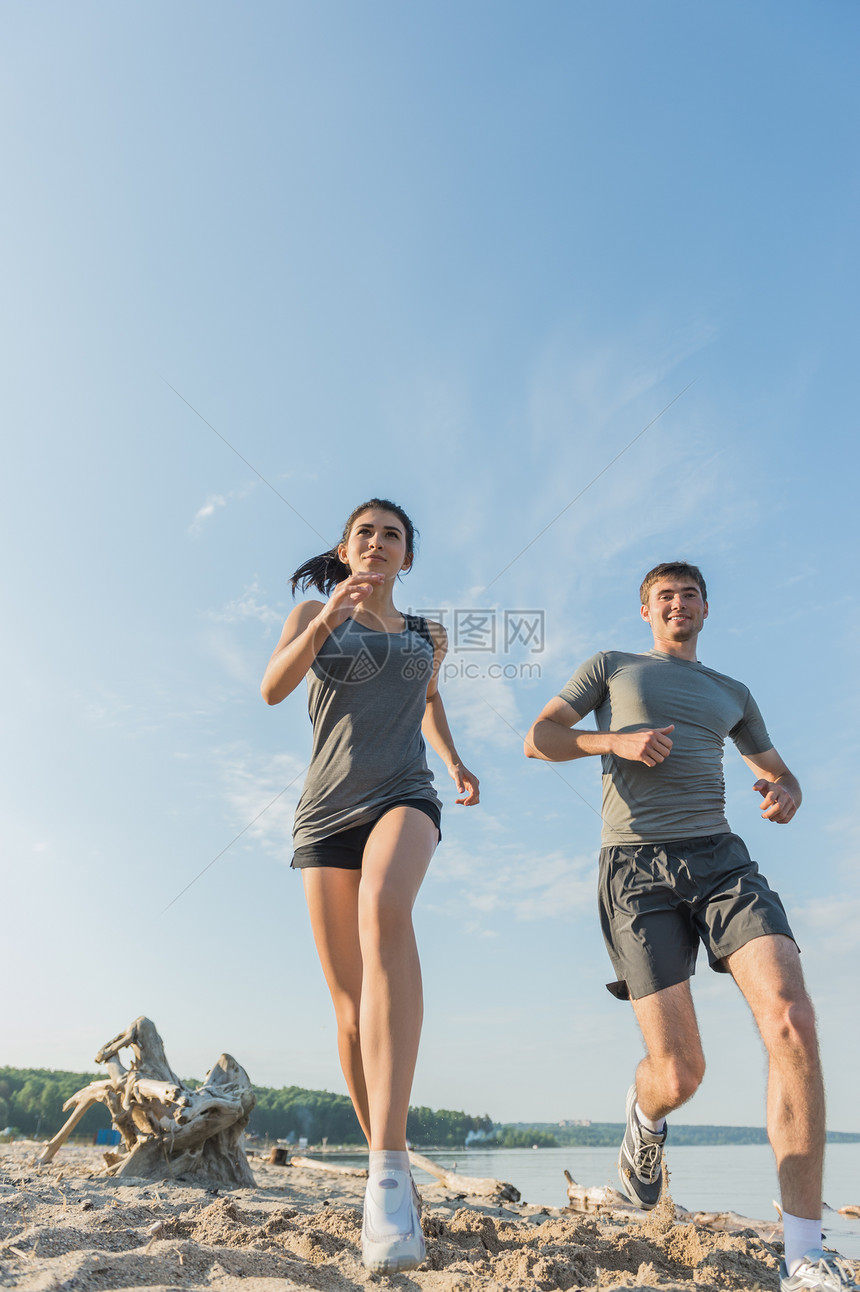 海滩跑步夫妇外慢跑跑步者户外训练,海边锻炼适合多种族健身夫妇,西牙裔女人,白种人男人图片