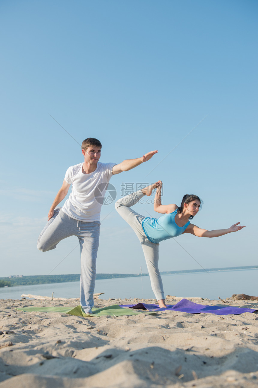 夫妇海滩练瑜伽图片