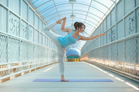 美丽的女人桥上练瑜伽,健康的生活方式健康的图片