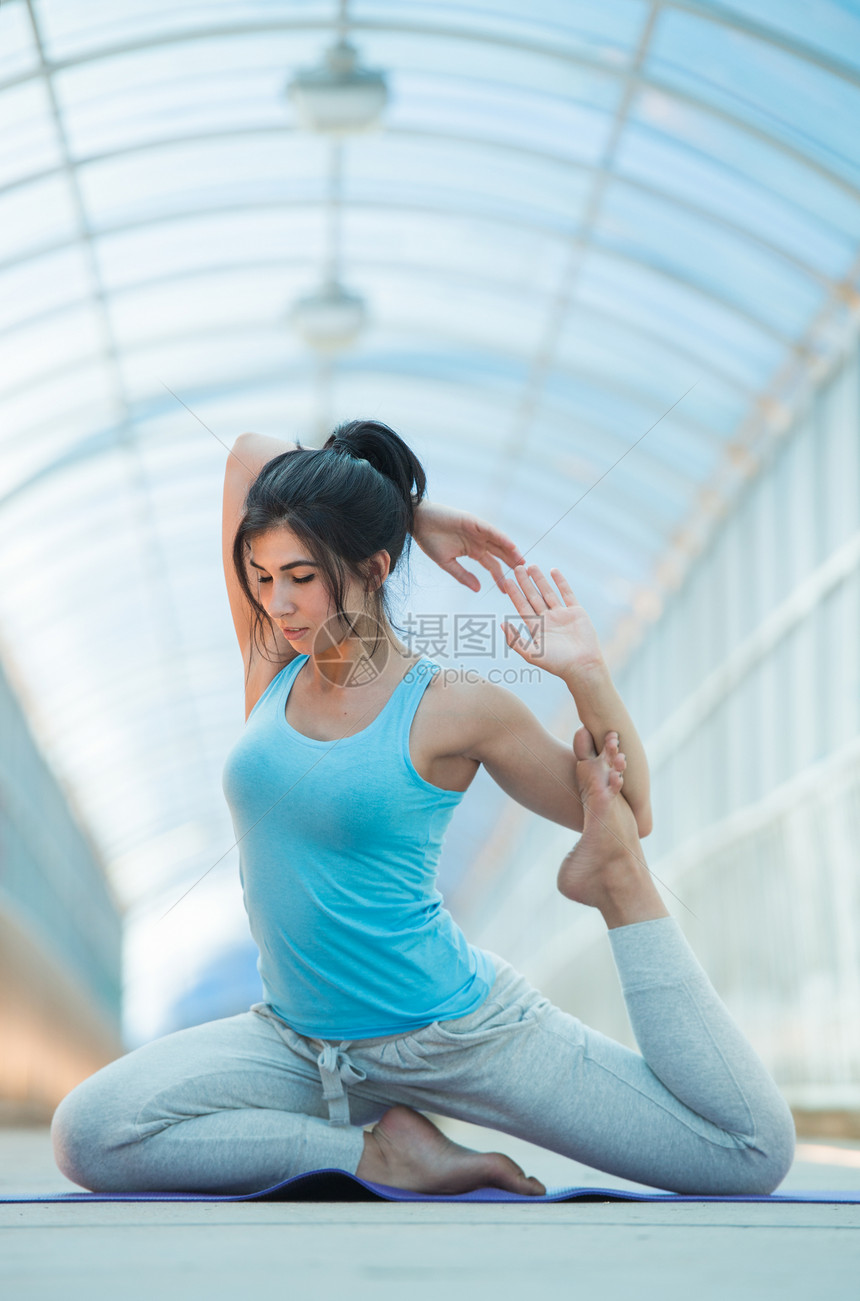 桥上户外伸展瑜伽运动的女人全长图片