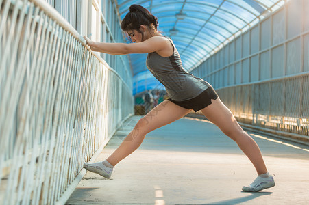 适合轻的女人跑步前伸展身体轻的女跑步者训练前伸展肌肉图片