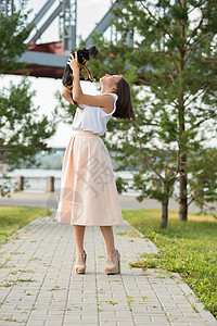 美丽的轻女人穿着优雅的连衣裙,抱着小狗,夏天的公园散步图片