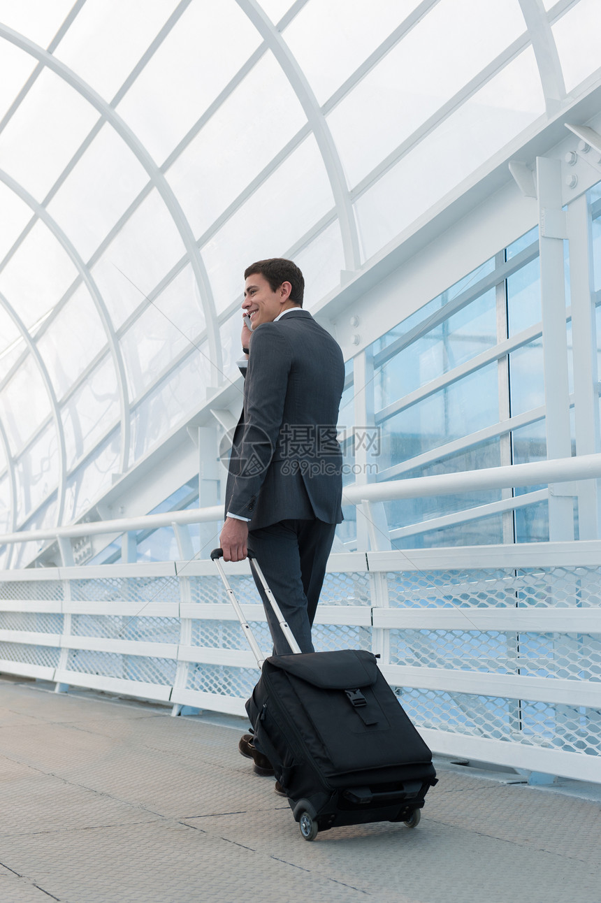 智能手机上的男人机场的轻商人休闲的城市专业商人用智能手机微笑快乐办公楼机场内穿着西装夹克的帅哥室内图片
