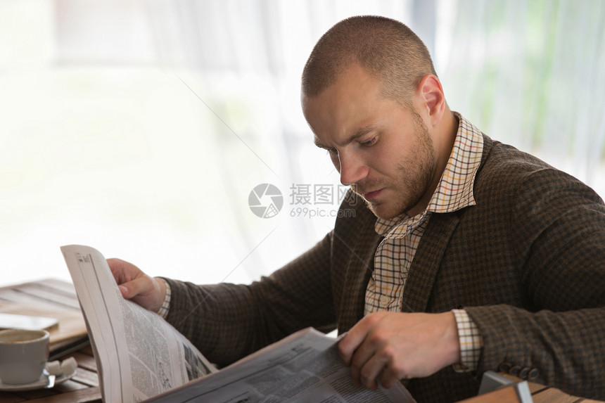 忧郁的商人咖啡馆里读报纸图片