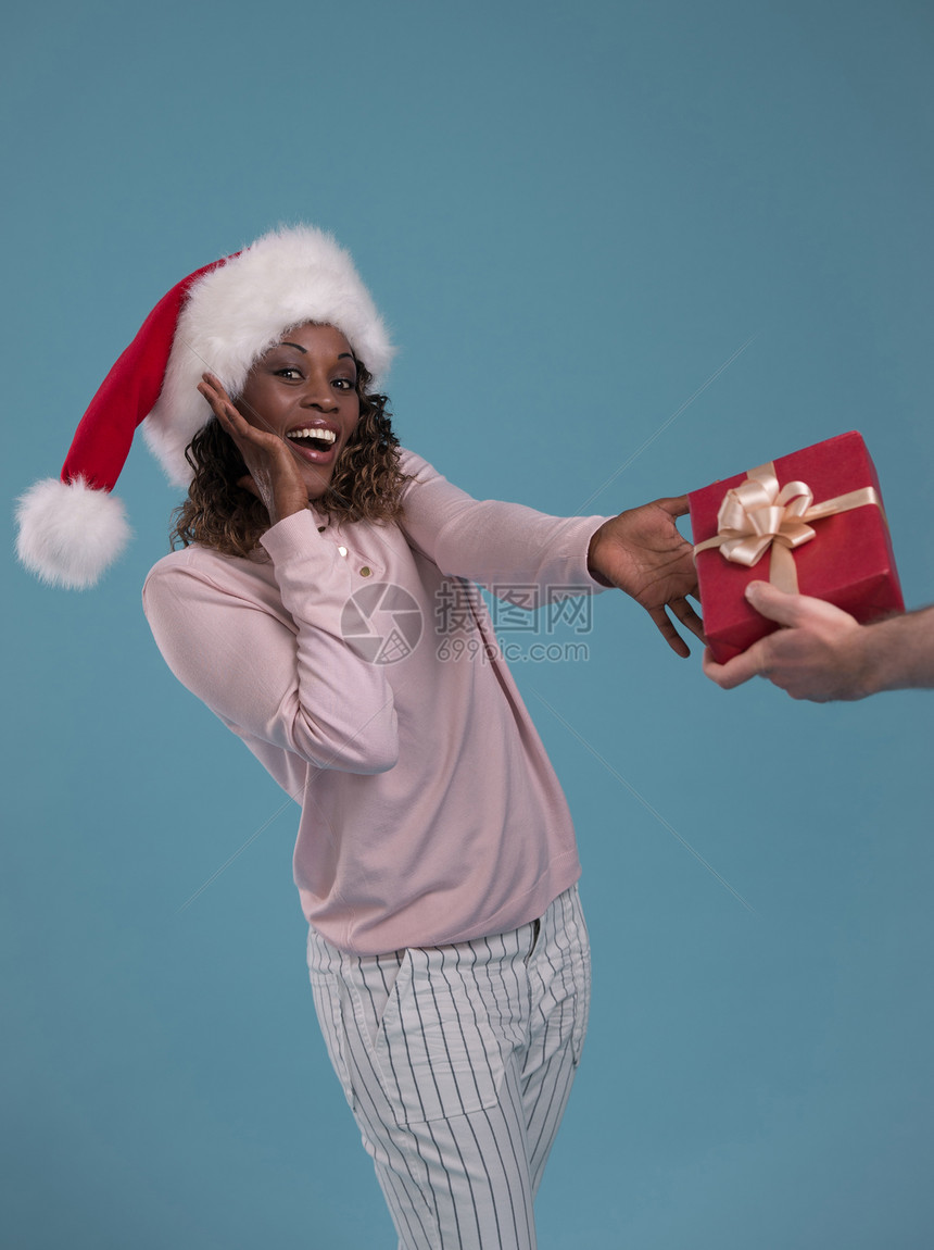 美丽的女人肖像着诞礼物蓝色背景上微笑快乐的非洲女孩图片