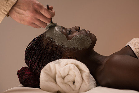 美丽的非洲女人,粘土膜,由美容师敷图片