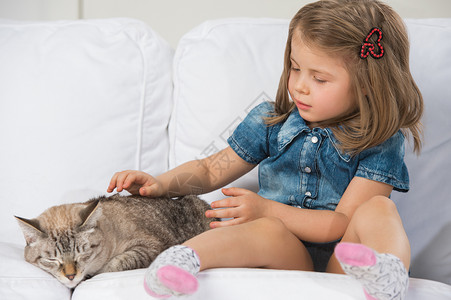 可爱的小女孩抱着塔比猫,看着猫图片