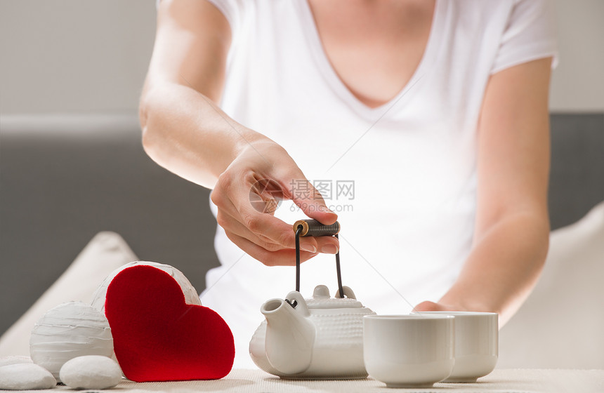 女手臂握着茶壶的详细镜头,欢迎加入饮酒明亮的心爱的象征爱,温柔关怀的图片