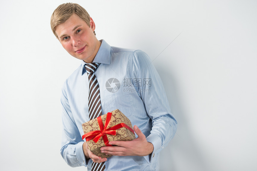 微笑的商人着红色丝带的礼品盒图片