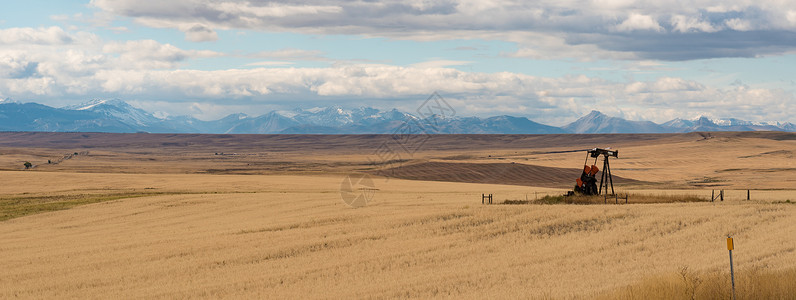 蒙大州座山脉后的油井图片