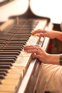 女钢琴家轻的女人弹钢琴双手特写视图背景