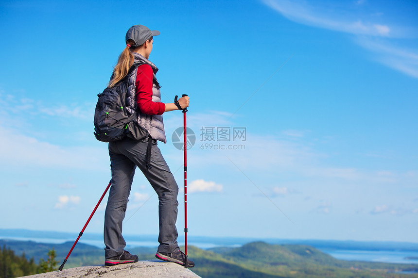 轻的女游客站山顶向边看图片