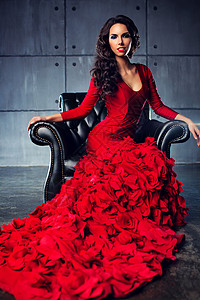 轻苗条感时尚女人穿着红色长裙坐椅子上图片