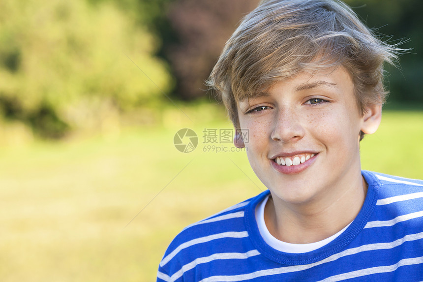 轻快乐微笑的男孩子,十几岁的金发孩子,夏天的阳光下穿着件蓝色的运动衫图片