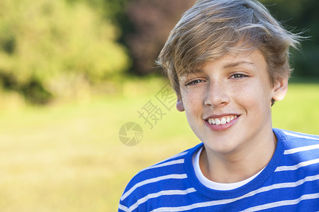 轻快乐微笑的男孩子,十几岁的金发孩子,夏天的阳光下穿着件蓝色的运动衫背景图片
