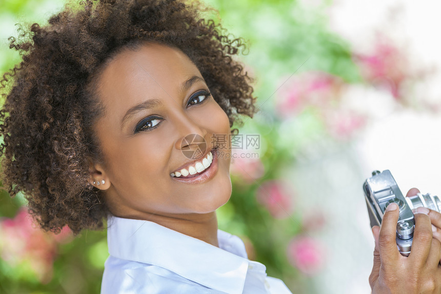个美丽的混血非裔美国女孩轻的女人,看来很高兴外用复古数码相机拍照拍照图片