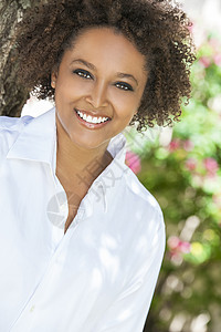 美丽的轻混血黑人非裔美国妇女,完美的牙齿,微笑放松外的夏季阳光图片