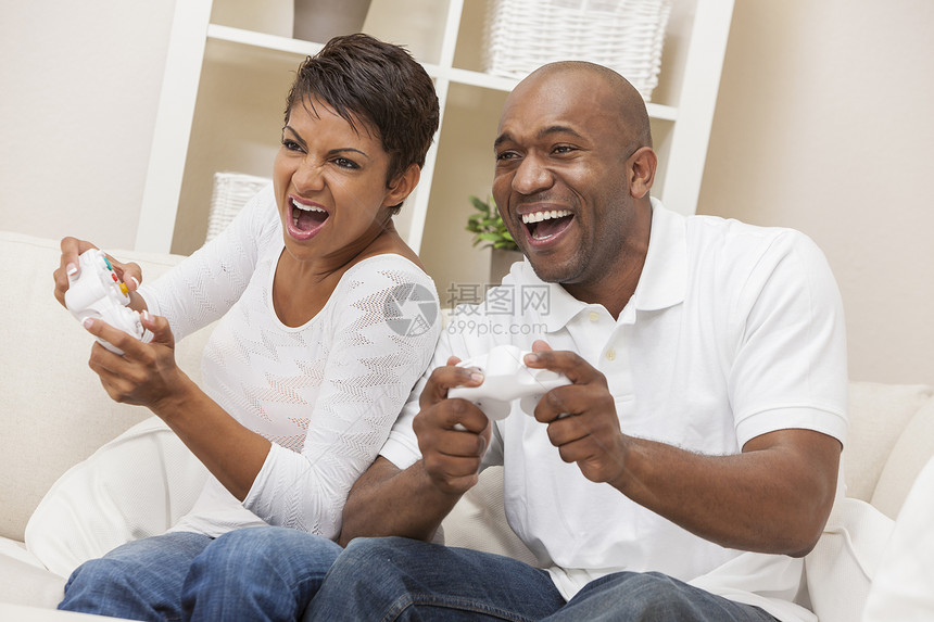 非裔美国人夫妇,男人女人,玩电子游戏机游戏很开心图片