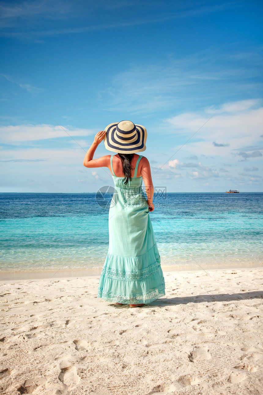 海滩度假马尔代夫沿着热带海滩散步的女孩图片