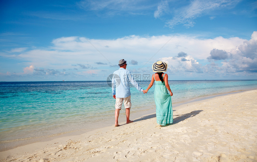 度假的夫妇热带海滩散步马尔代夫男人女人浪漫地海滩上散步图片