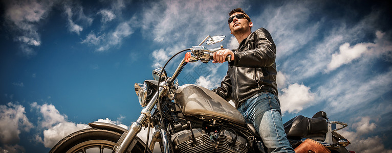骑自行车的人穿着皮夹克太阳镜坐摩托车上背景图片