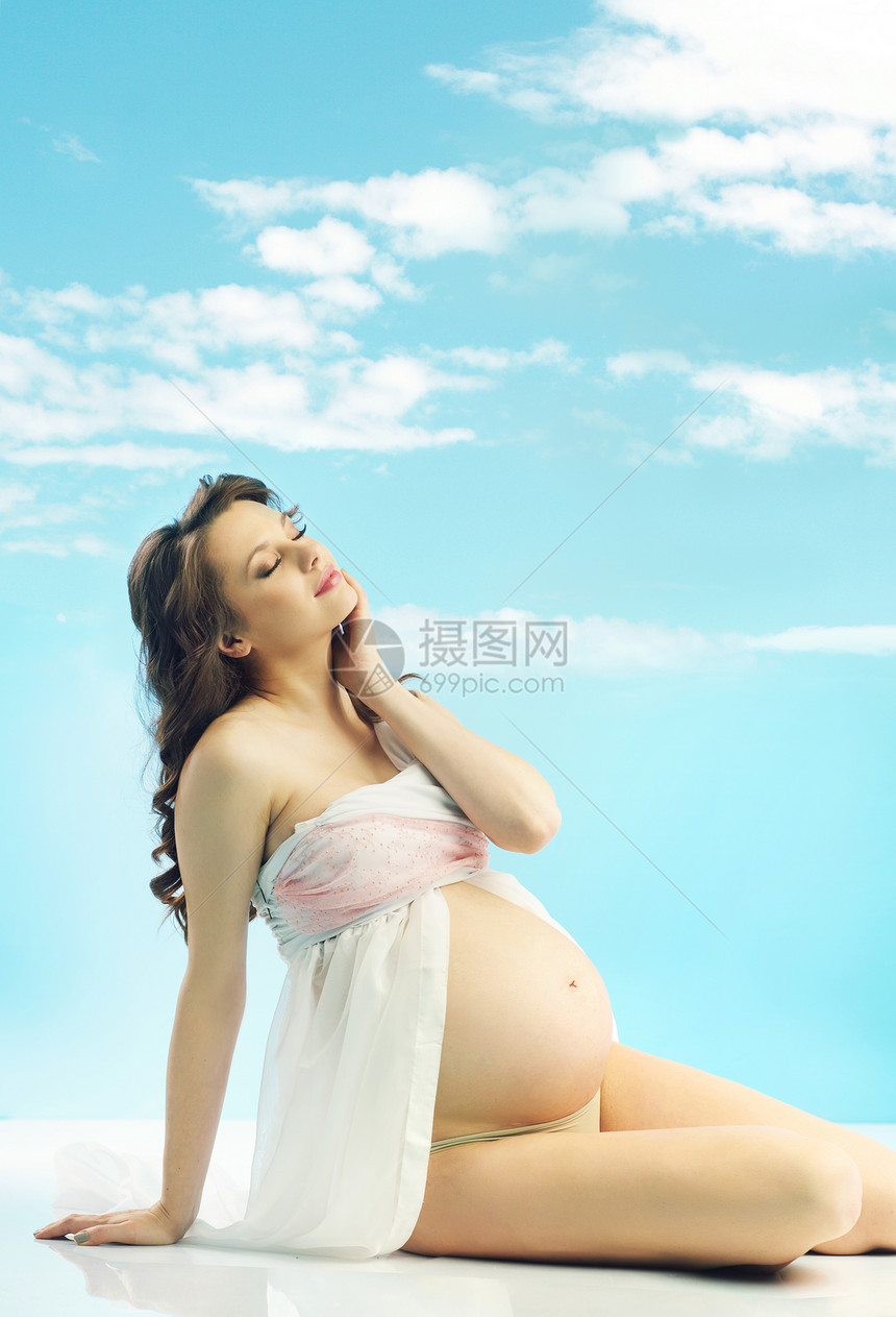 放松美丽的孕妇与卷曲的头发图片