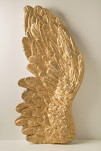 金色鸟装饰金色羽毛的巨大翅膀背景